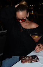 Black chunky knit sweater with an off-shoulder neckline