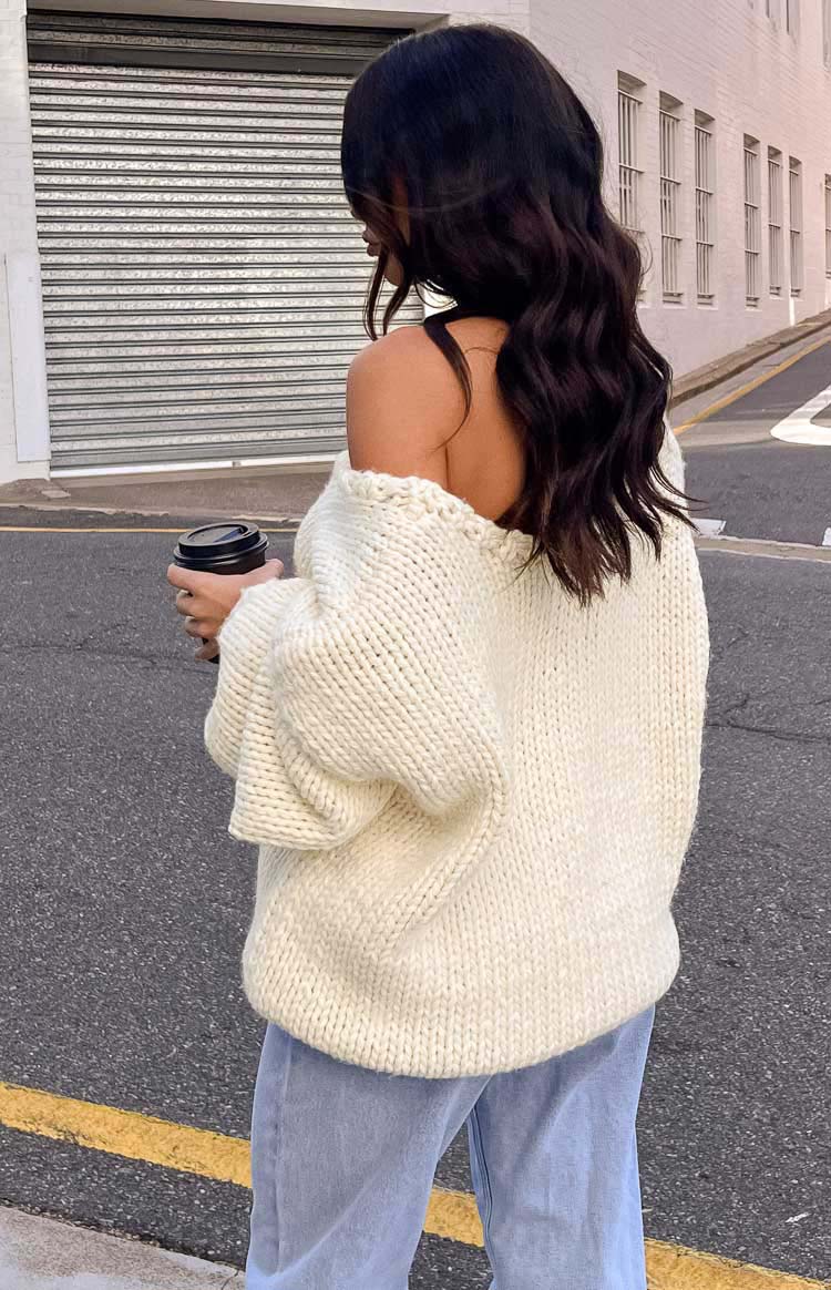 Rear view of the cream chunky knit sweater, highlighting the off-shoulder neckline and thick knit texture