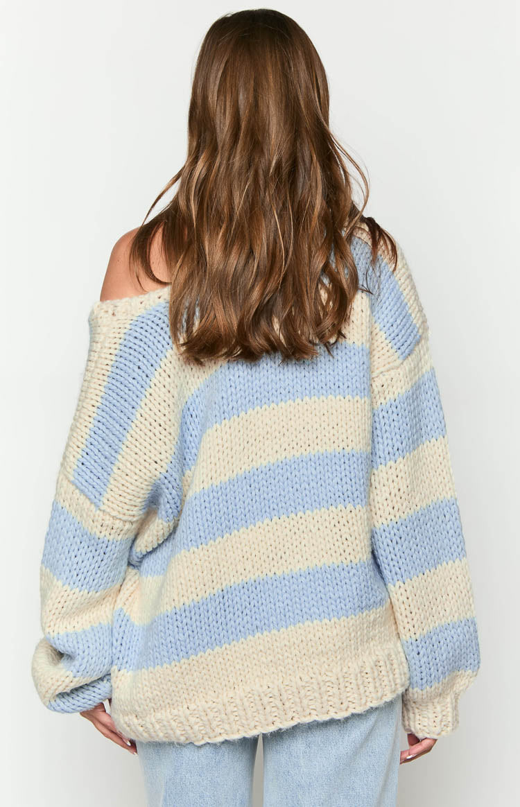 Rear view of the light blue and cream striped chunky knit sweater with thick horizontal stripes and a relaxed oversized fit