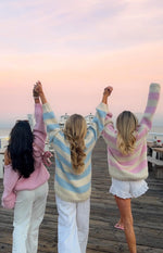 Rear view of a light pink chunky knit sweater with an off-shoulder neckline