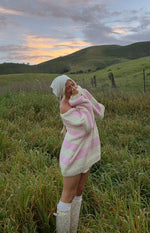 Pink and cream striped chunky knit sweater with an off-shoulder neckline and longline fit