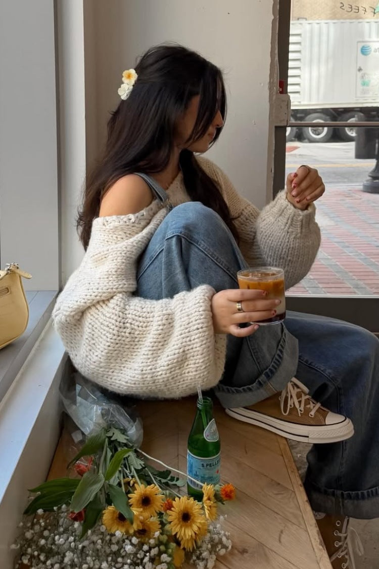 Cream chunky knit sweater with a wide off-shoulder neckline and voluminous long sleeves with ribbed cuffs