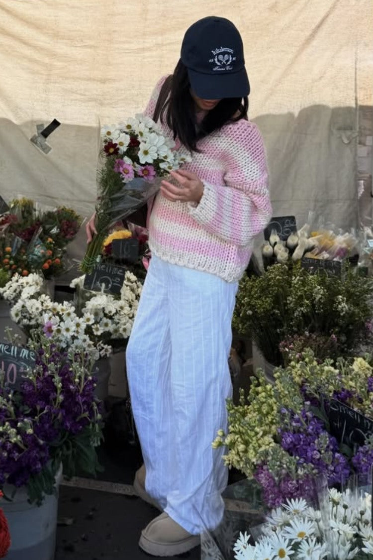 Relaxed fit pink and white striped chunky knit sweater with wide sleeves and a scalloped hem