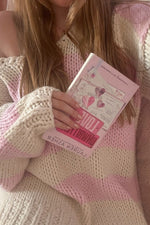 Close-up of the chunky knit texture on a pink and cream stripe oversized sweater