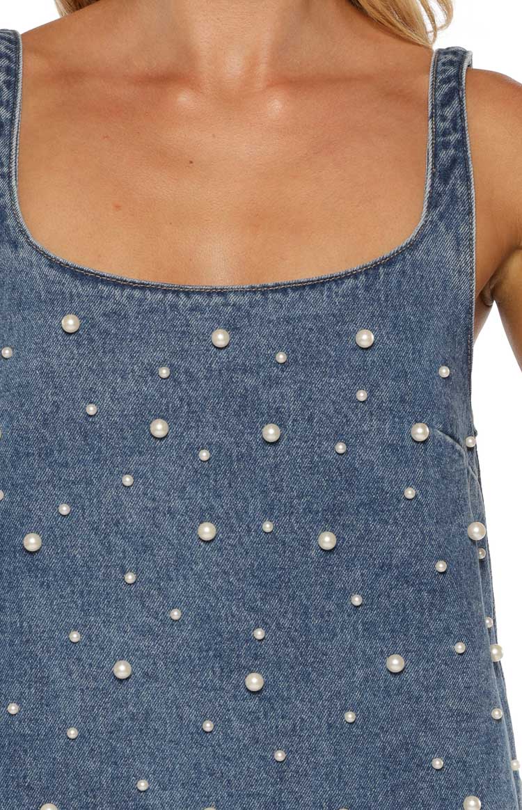 Close-up of the blue denim mini dress showing the scoop neckline and scattered white pearl details