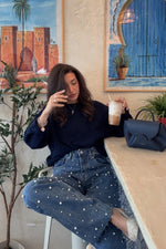 Mid wash high waisted jeans with scattered pearl embellishments and a relaxed fit