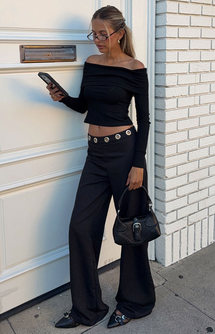 Close-up of the silver eyelet detail along the waist of black straight leg pants