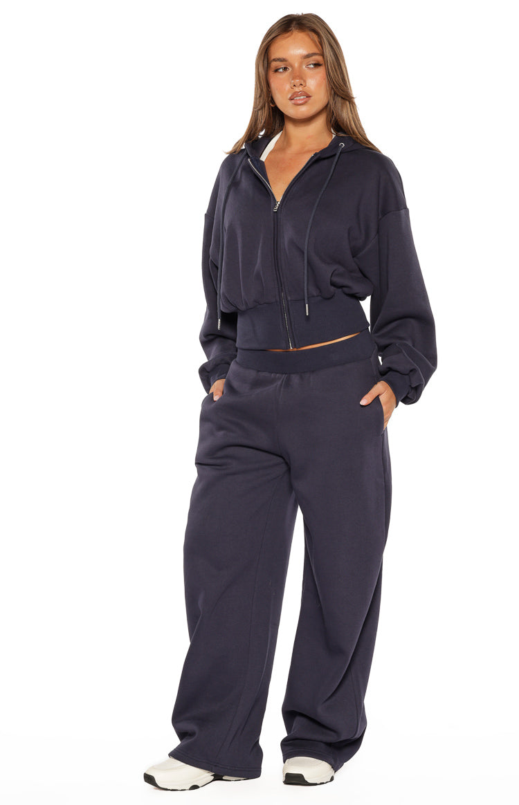 Navy barrel leg track pants with a wide, relaxed fit, elasticated waistband, and side pockets