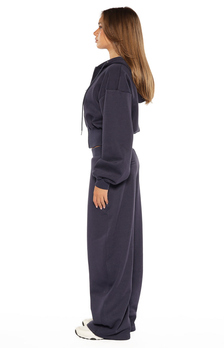 Side view of navy barrel leg track pants with a relaxed, curved silhouette