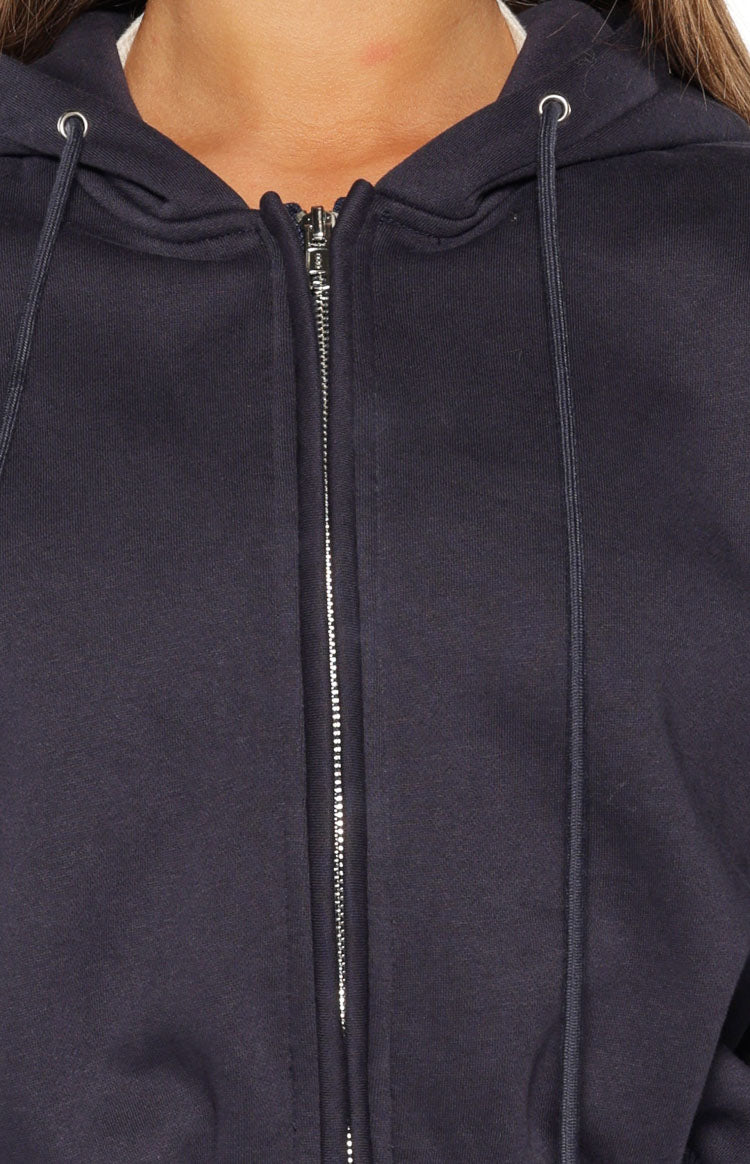 Close-up of the navy fleece zip hoodie showing the silver zipper and hood drawstring