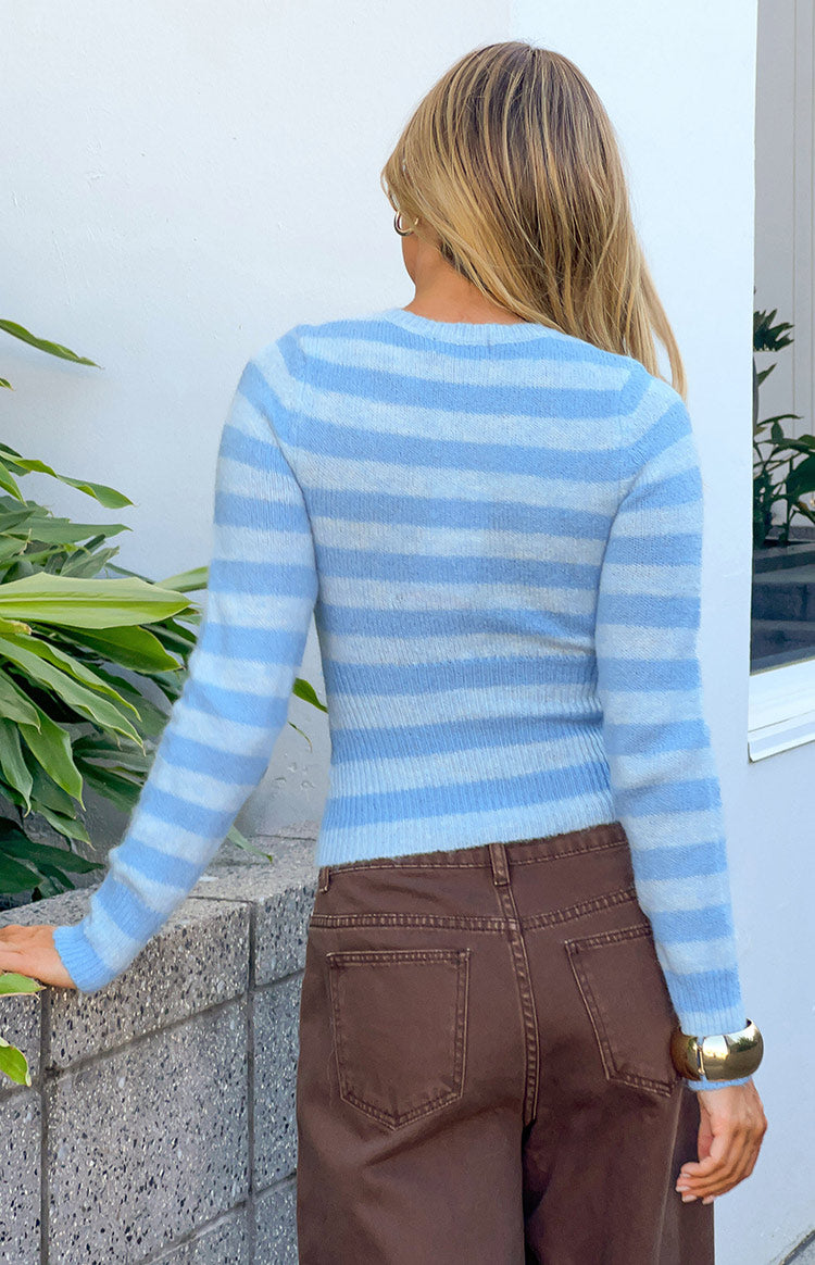 Rear view of a blue and white horizontal striped knit sweater with a round neck and fitted, cropped length