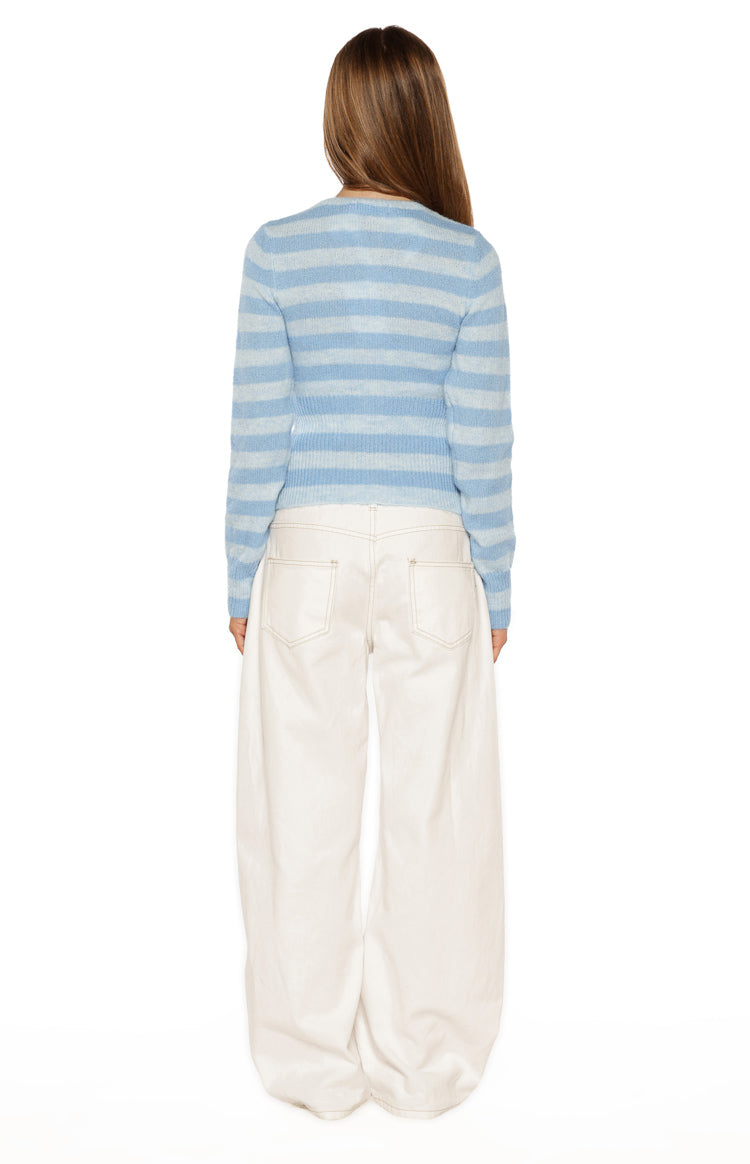 Rear view of a blue and light blue striped knit sweater with long sleeves and a ribbed hem