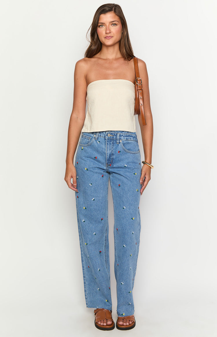 Light blue denim straight leg jeans with colourful floral embroidery and an uneven waist