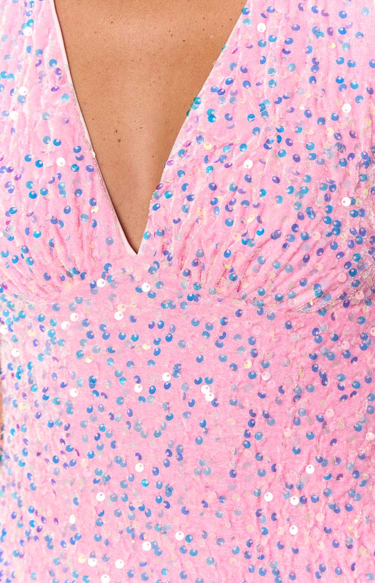Detail shot of the pink sequin fabric with iridescent blue sequins and the deep V-neckline of the mini dress
