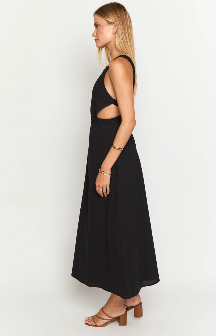 Side view of a black textured midi dress with waist cutouts and a flowy A-line skirt