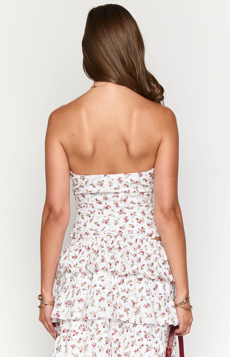 Rear view of a fitted white strapless top with a small red and yellow floral pattern