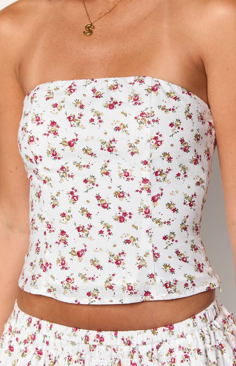 Close-up of the white strapless top showing the small red and green floral print and fitted bodice seams