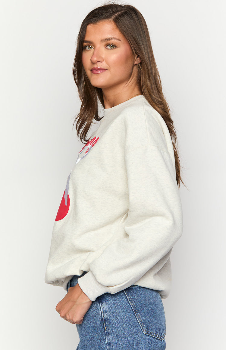 Side view of an oat marle crew neck sweater showing the relaxed fit and ribbed cuffs