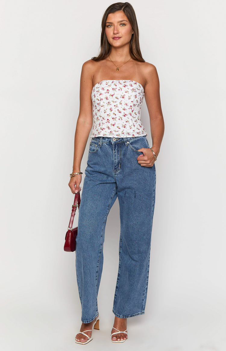 White strapless top with a red and green floral print, fitted and cropped to the waist