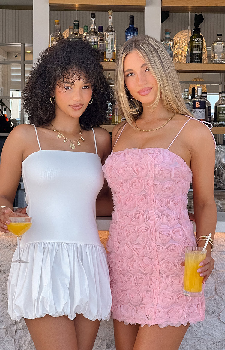 Front view of a white mini dress with a square neckline, thin spaghetti straps, and a gathered bubble skirt