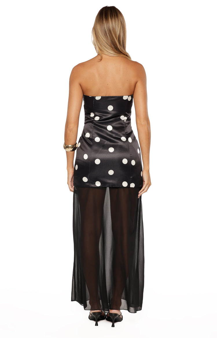 Rear view of a black strapless polka dot maxi dress with a satin mini dress under a sheer maxi skirt overlay