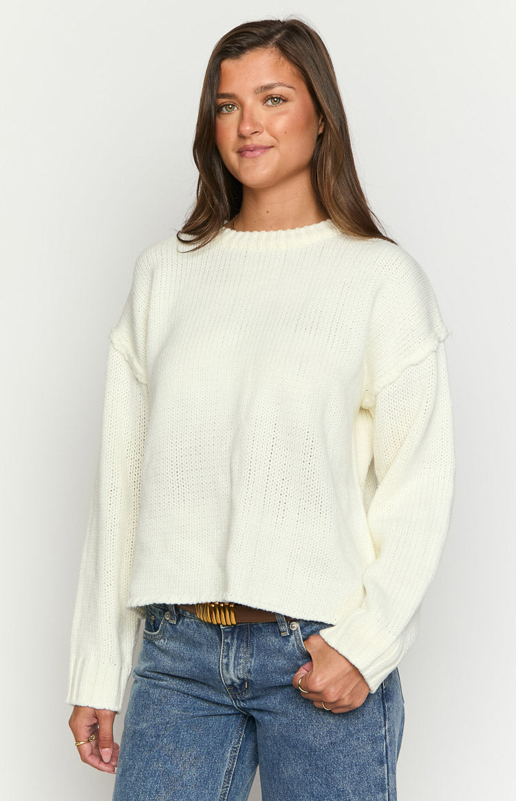 Textured cream knit sweater with raw edge shoulder seams and ribbed cuffs