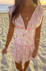 Pink floral mini dress with a deep V-neck, tie-shoulder cap sleeves, fitted bodice, and ruffled skirt