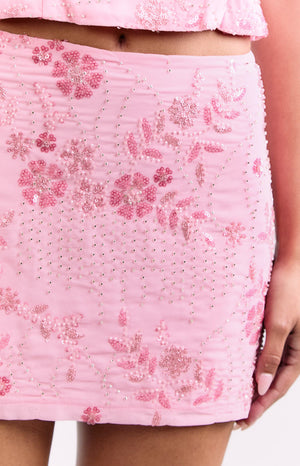 Close-up of the light pink mini skirt with ruched fabric and pink floral sequin and bead embroidery
