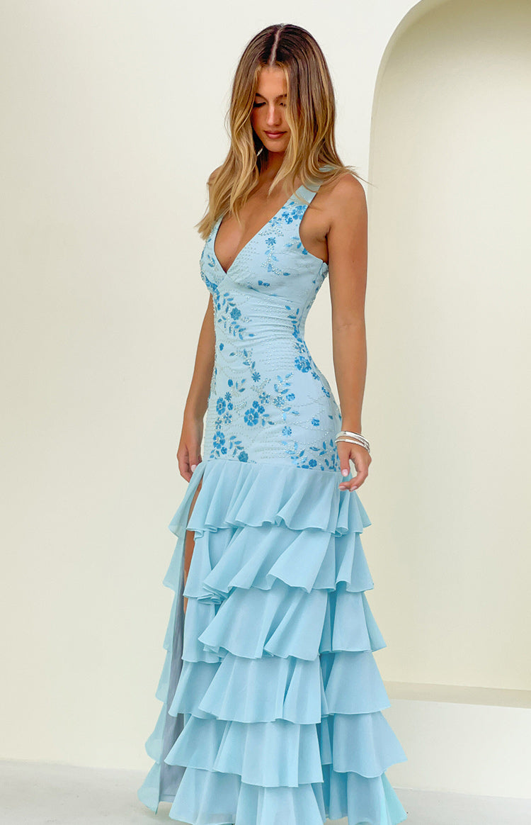 Side view of a light blue sequin maxi dress showing the V-neck, floral embroidery, high leg slit, and tiered ruffle hem