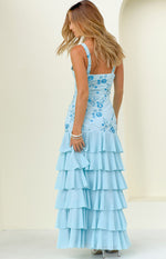 Rear-side view of a light blue sequin maxi dress with floral embroidery on the bodice and a full tiered ruffle skirt