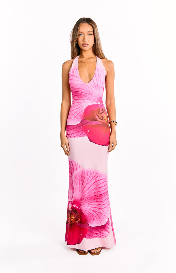 Front view of a pink maxi dress featuring a deep V-neck halter and vibrant large-scale orchid print