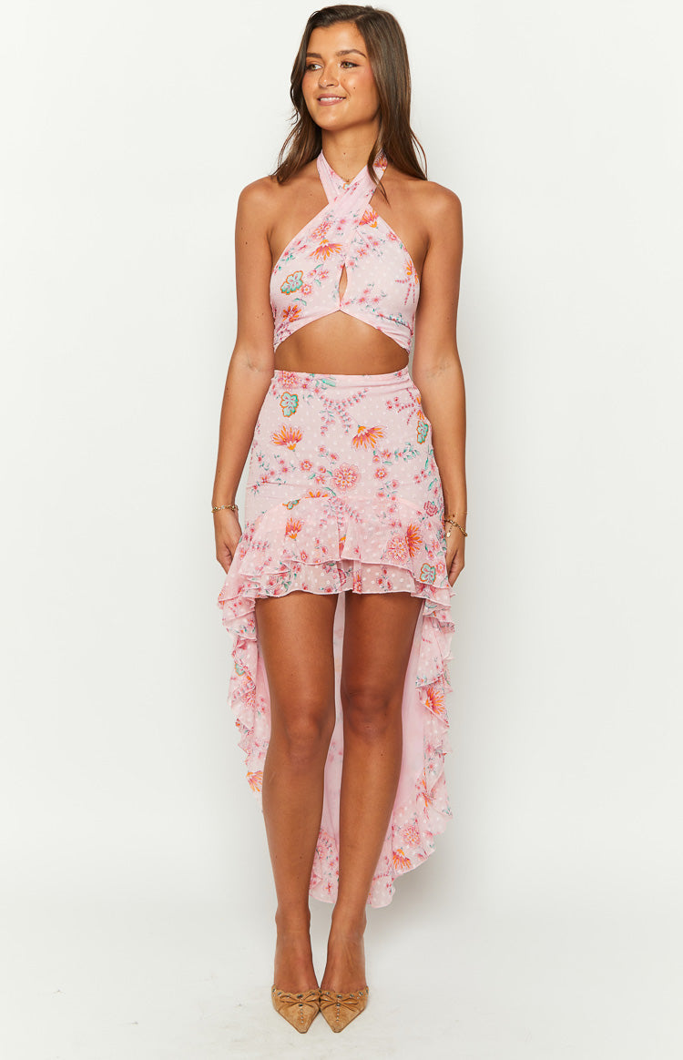 Front view of a pink floral maxi skirt with a ruffled high-low hem and white polka dots