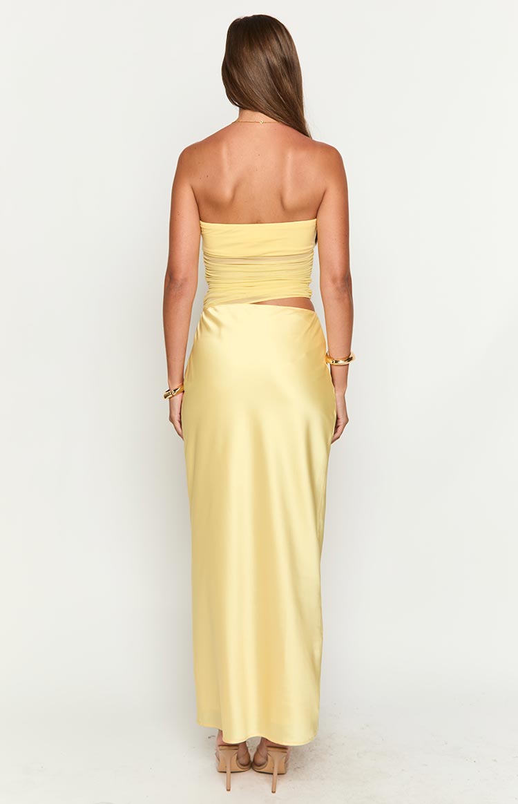 Rear view of the yellow strapless maxi dress with a ruched bodice, sheer mesh panel, and back cutout