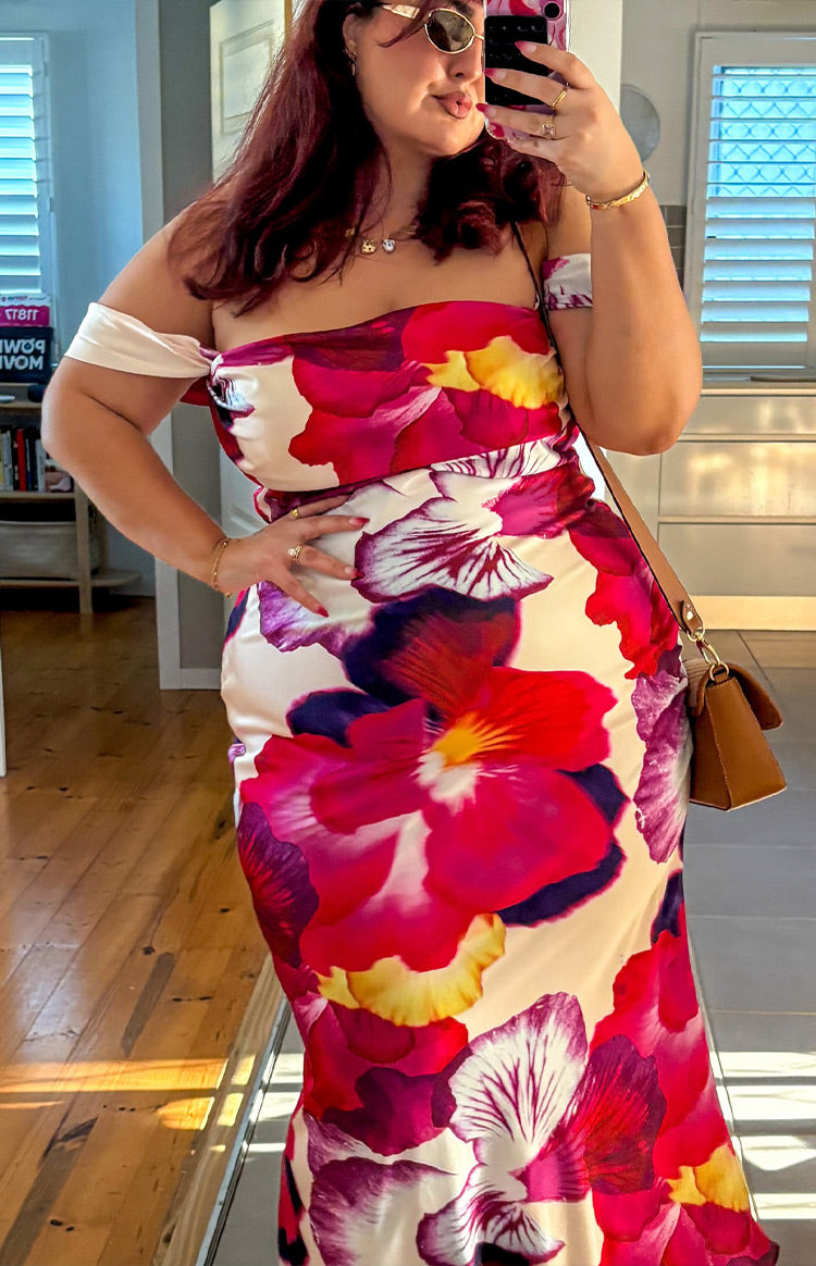 Off-shoulder detail with a light pink band and the vibrant pink, purple, and yellow floral print on the fitted formal dress