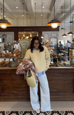 Full length view of a butter yellow button-down cardigan with a crew neck, relaxed fit, and ribbed hem