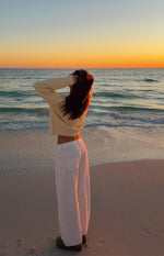 Back and side view of white denim barrel leg jeans, showing the wide, curved leg and back pockets