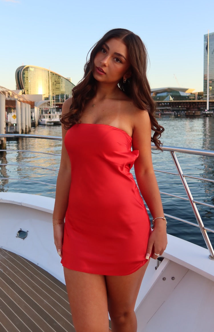 Front view of a red satin strapless mini dress with a fitted bodice and subtle side drape
