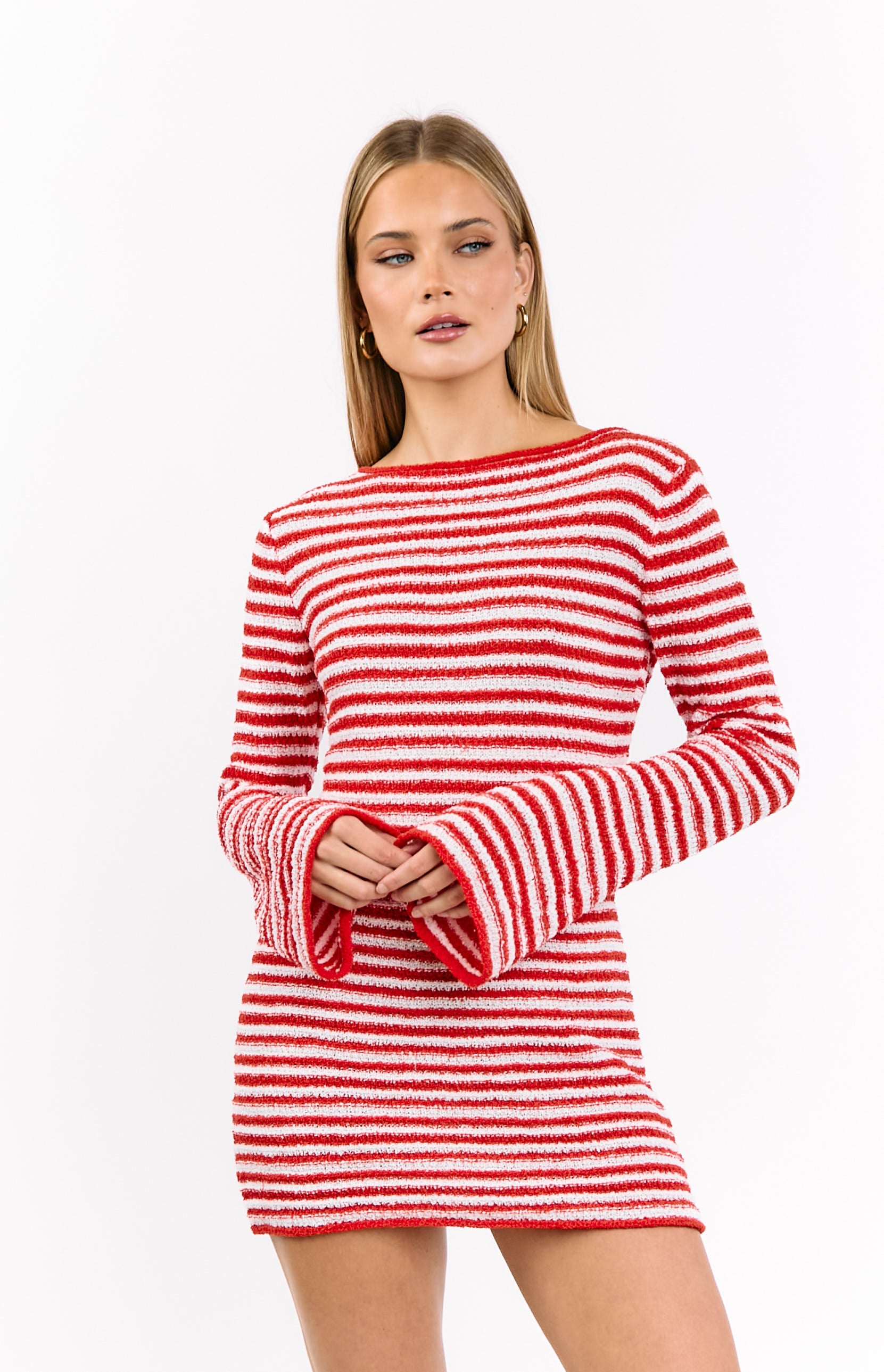 Front view of a red and white striped knit mini dress with a boat neck and long flared sleeves