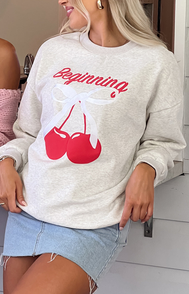 Beginning Boutique Elodie Oat Marle Cherry Print Crew Neck Sweater oat marle relaxed fit crew neck sweater with red cherry graphic and 'Beginning' text