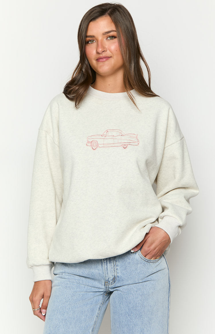 Close-up of the red embroidered classic car graphic on the front of a grey crew neck sweater