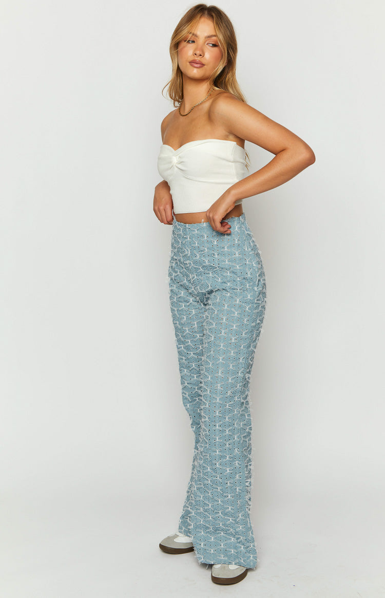 Side view of blue chambray flared jeans with a white bow pattern and a high waist