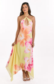 Front view of a yellow hibiscus floral halter maxi dress with keyhole cutout and flowy handkerchief hem