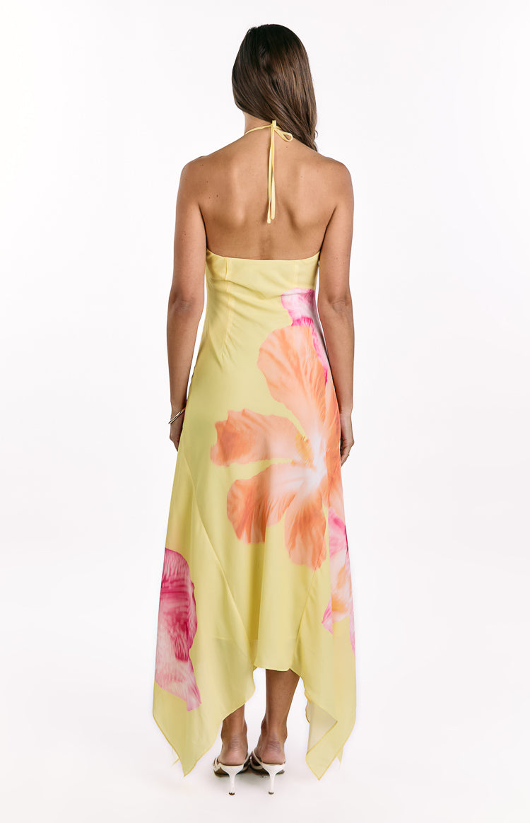 Rear view of a yellow hibiscus floral halter maxi dress with a handkerchief hem