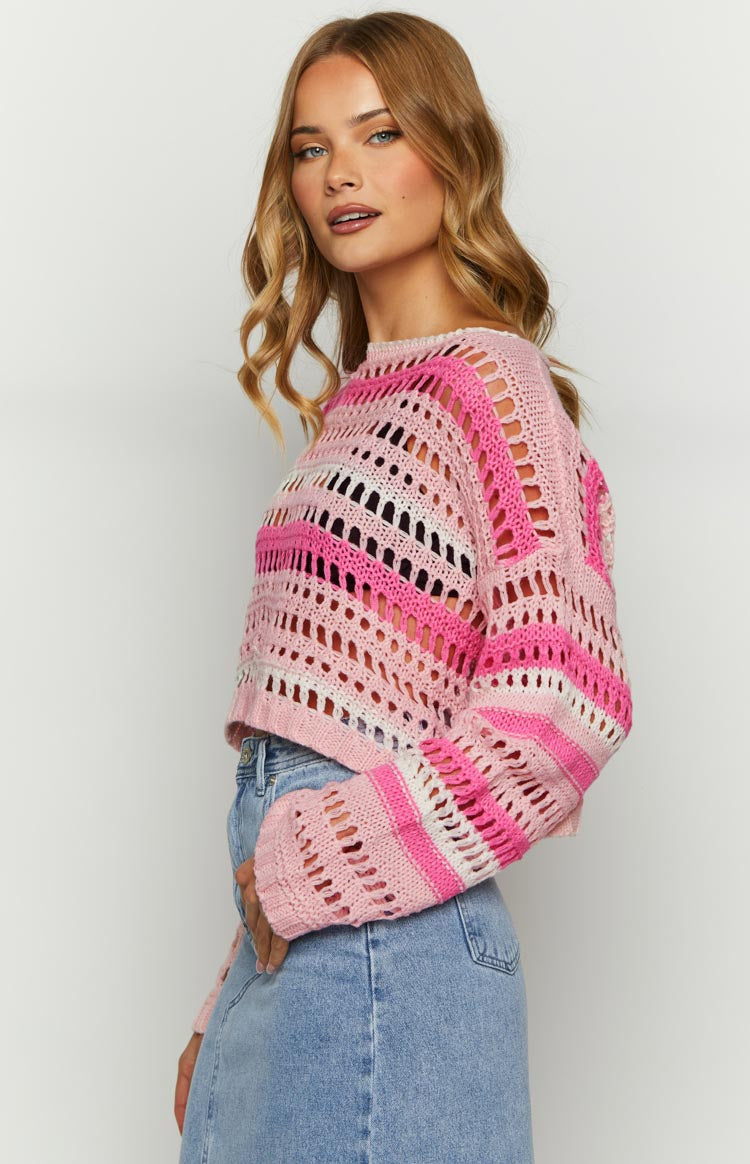 Side view of a multi pink open knit cropped jumper with horizontal stripes and long sleeves