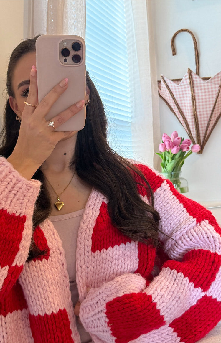 Close-up of the chunky knit pink and red checkered cardigan, highlighting the thick texture