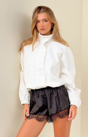 Cream crinkled funnel neck sports jacket with raglan sleeves, snap closure, and elasticated hem