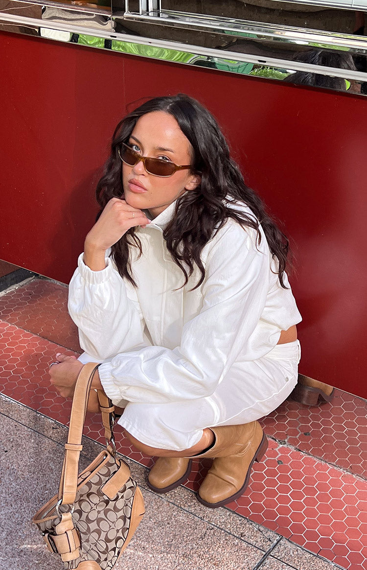 Cream funnel neck sports jacket with elasticated cuffs and hem, showing a relaxed cropped fit