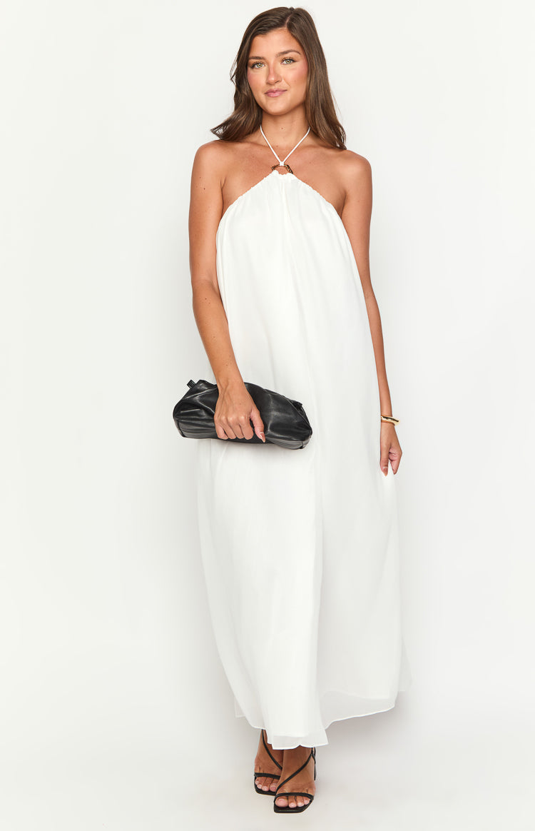 White flowy maxi dress with a halter neckline featuring a small gold ring detail and a relaxed silhouette
