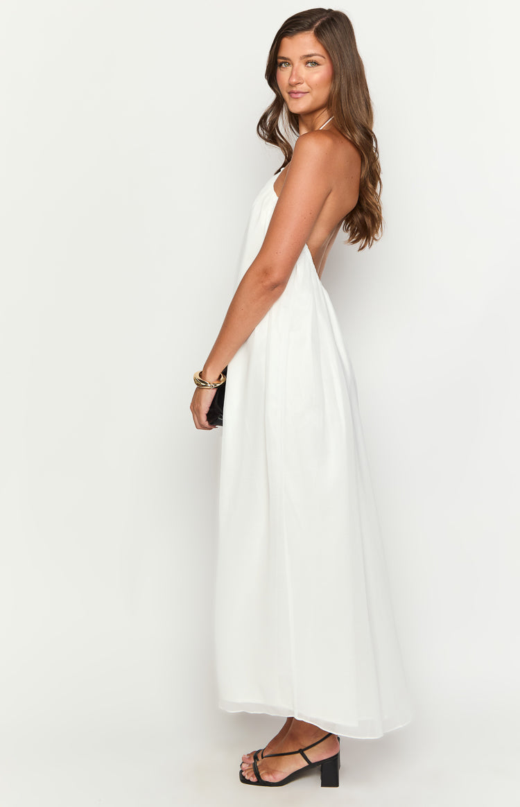 Side view of a white flowy maxi dress with a halter neckline and open back design