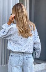 Rear view of a light blue polka dot sports jacket with elasticated cuffs and a relaxed fit